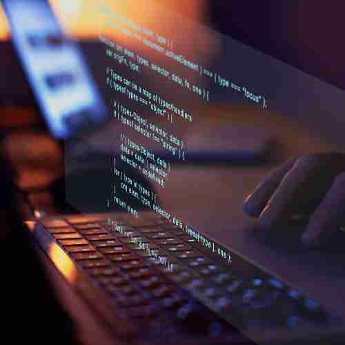 Un clavier d'ordinateur sur lequel quelqu'un code un site web. Un clavier d'ordinateur sur lequel quelqu'un code un site web. Une image en transparence montre ce qui est écrit à l'écran.