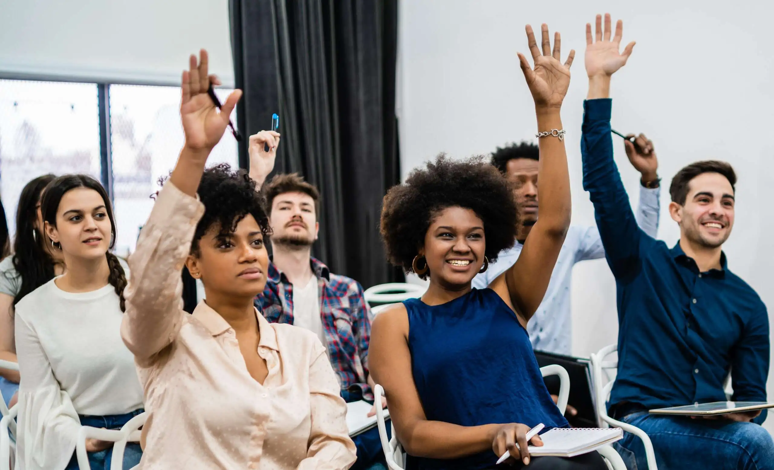 groupe-jeunes-assis-conference-ensemble-scaled Groupe de personne qui suit une formation dans une salle de classe.