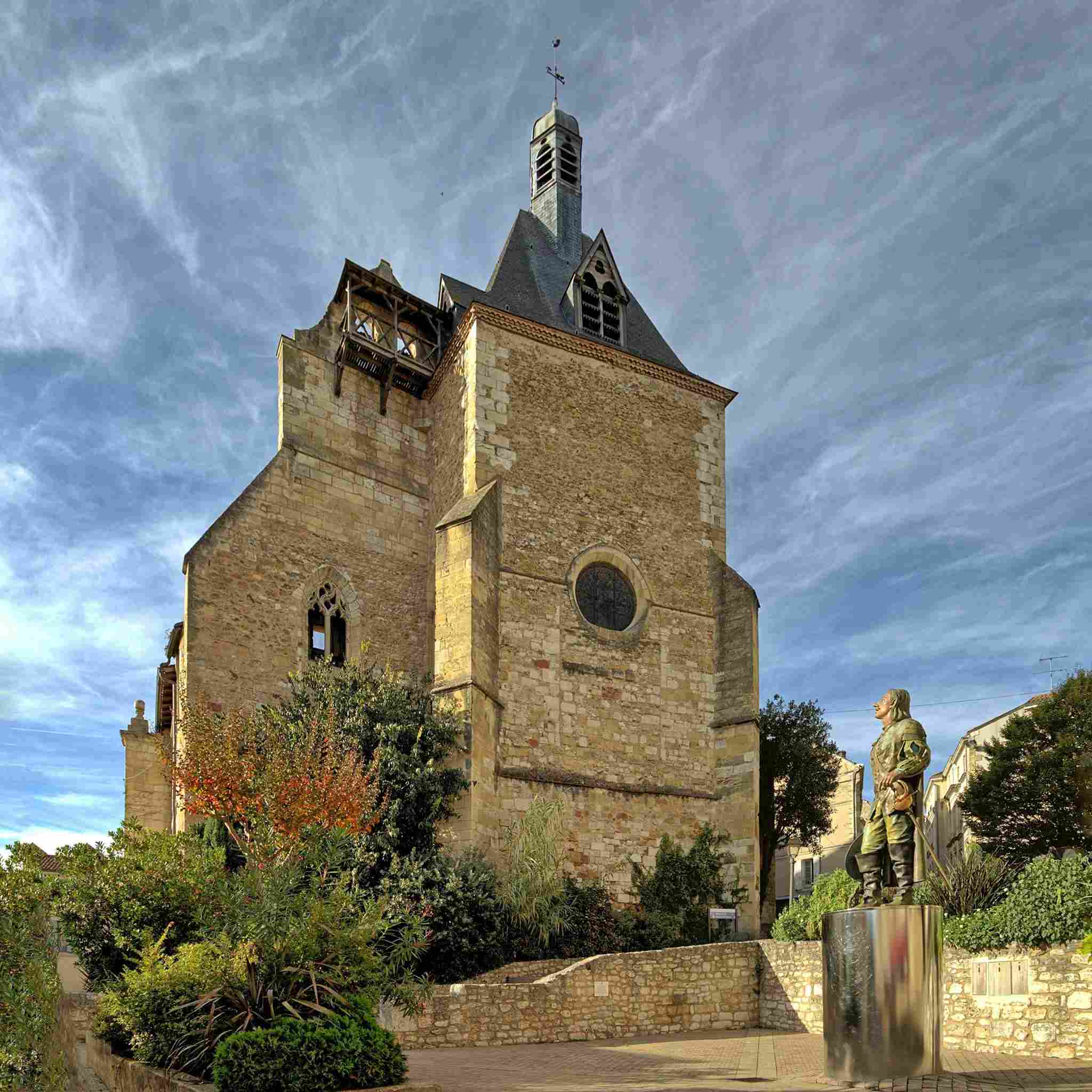 Statue de Cyrano de Bergerac dans le centre historique de Bergerac. La statue se situe en face d'une vieille église.