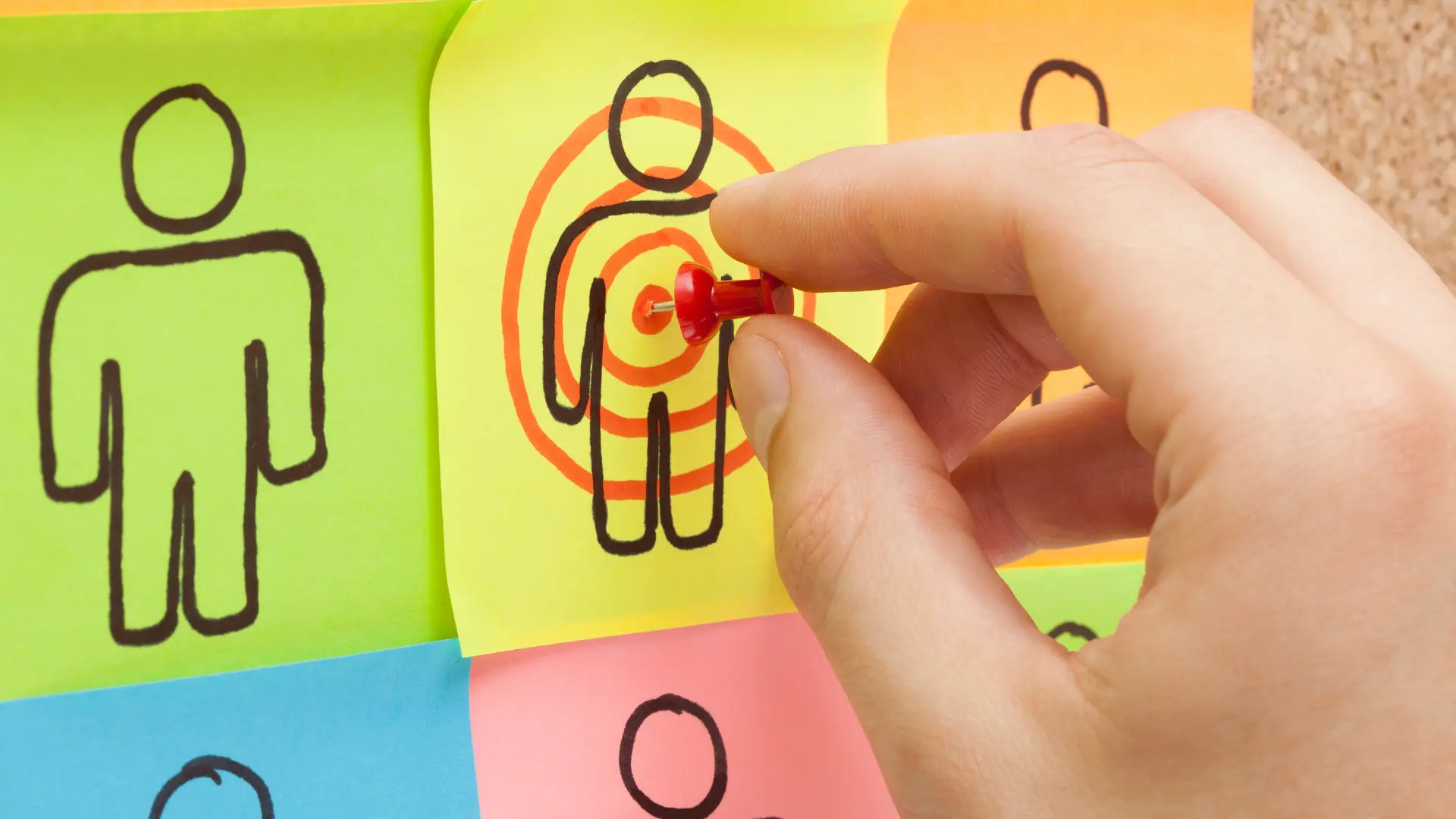 formation-persona-marketing Une personne plantant une punaise sur une cible, son persona marketing en l'occurrence.