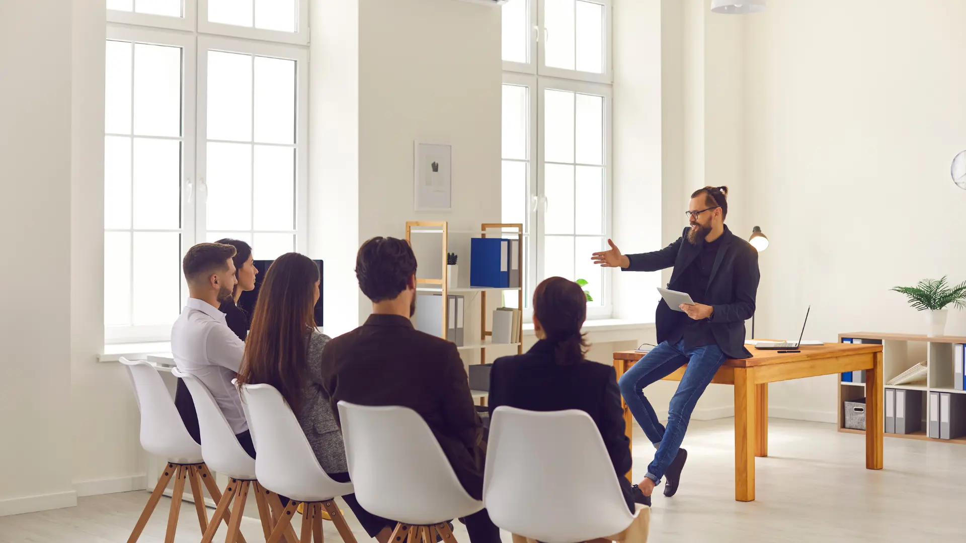 Un groupe de personne suivant une formation initiale dans une salle de classe et assis devant un professeur.