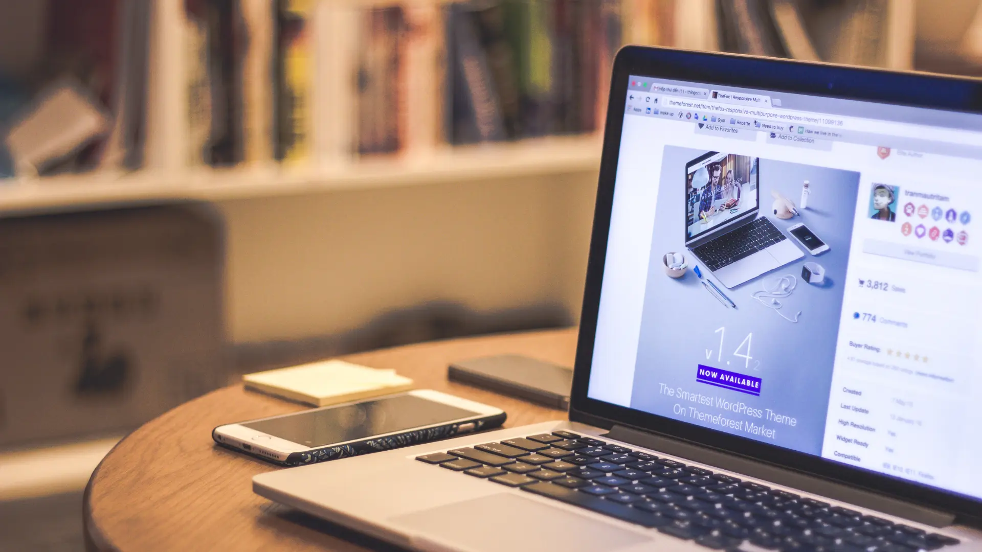 Un pc portable ouvert sur un logiciel de création de site internet disposé sur une table basse.