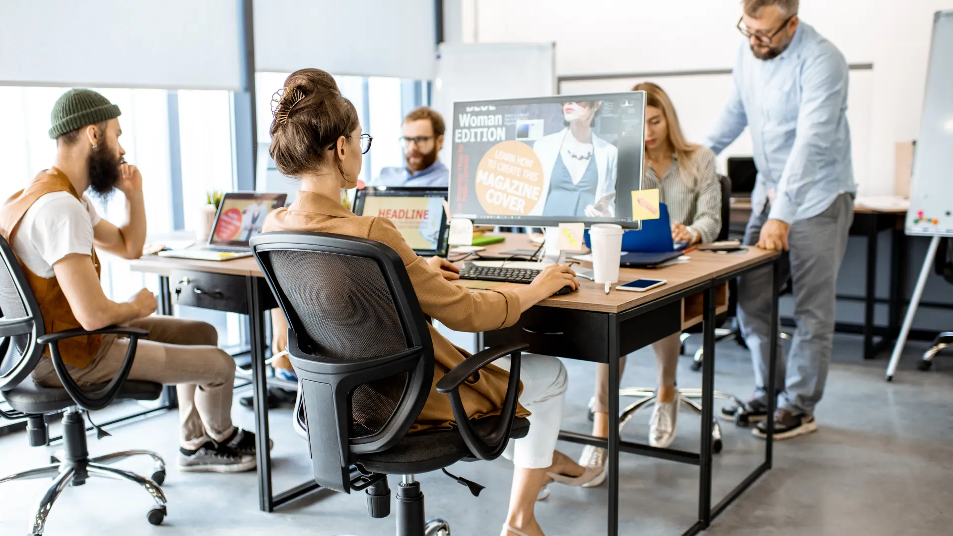 Groupe de web designer dans une agence web en train de travailler dans un open space.