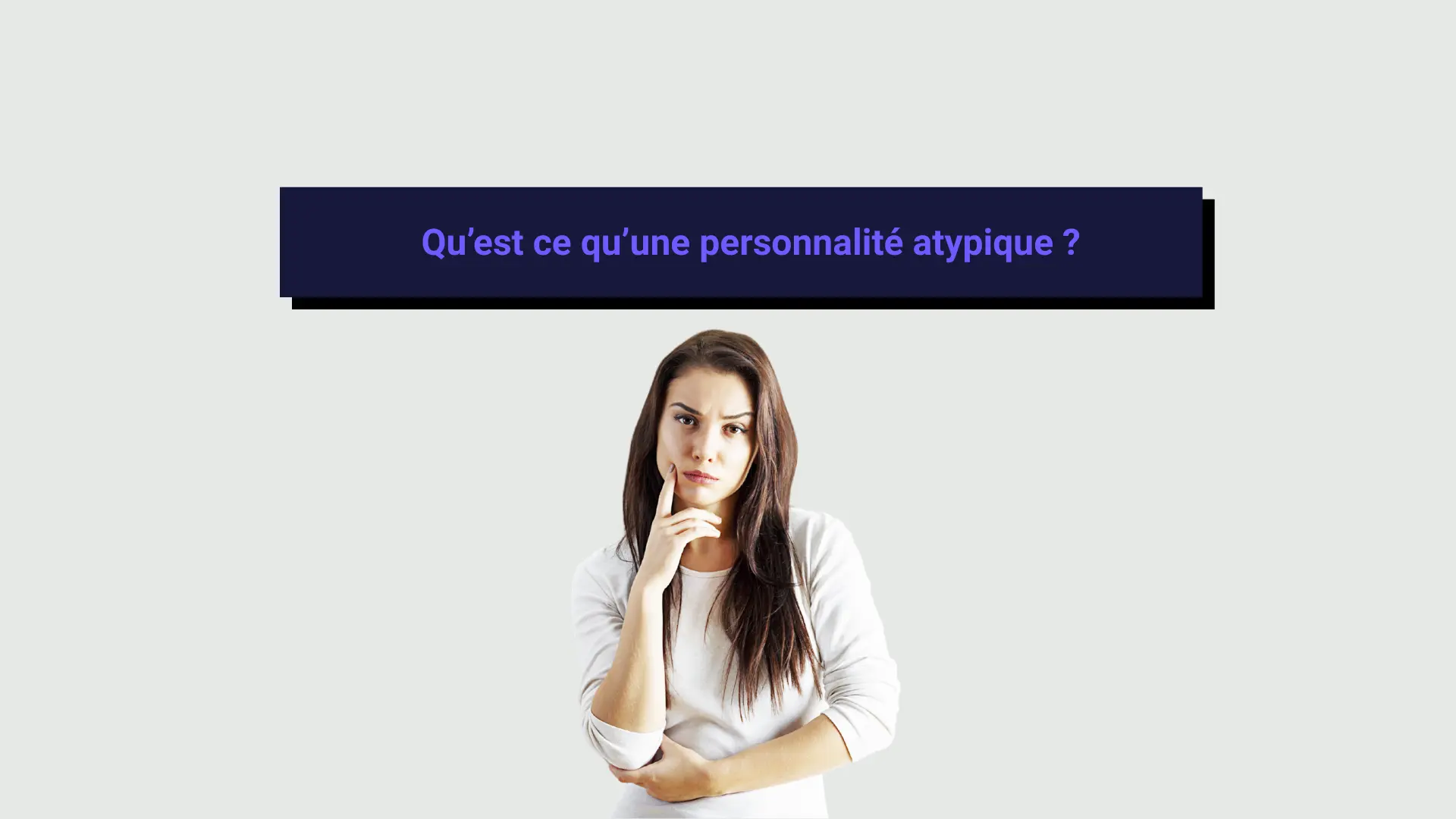 personalite_atypiques Une femme atypique réfléchie de face sur un fond gris.